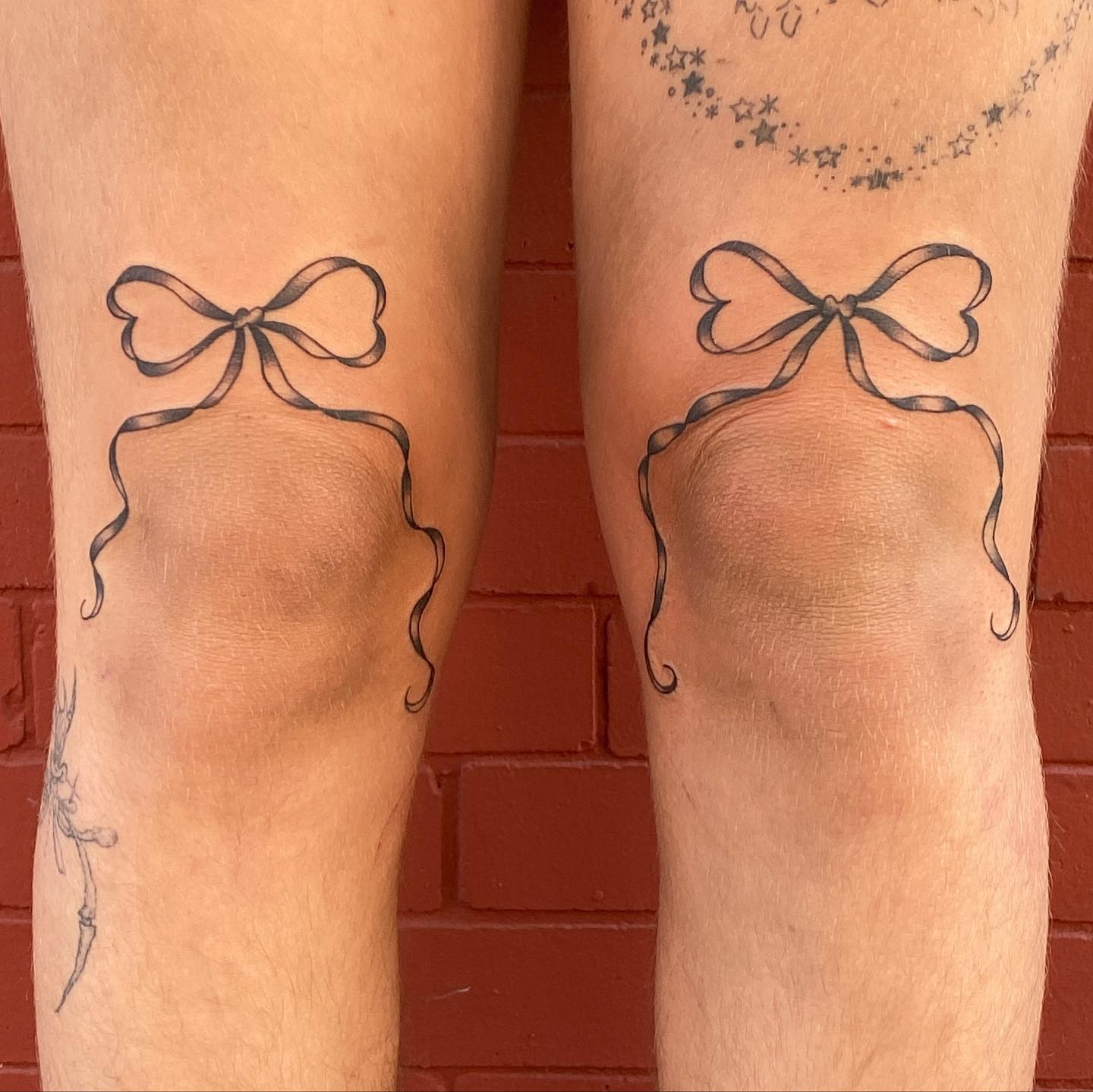 Thin Ribbon Bow Tattoo On Both Thighs