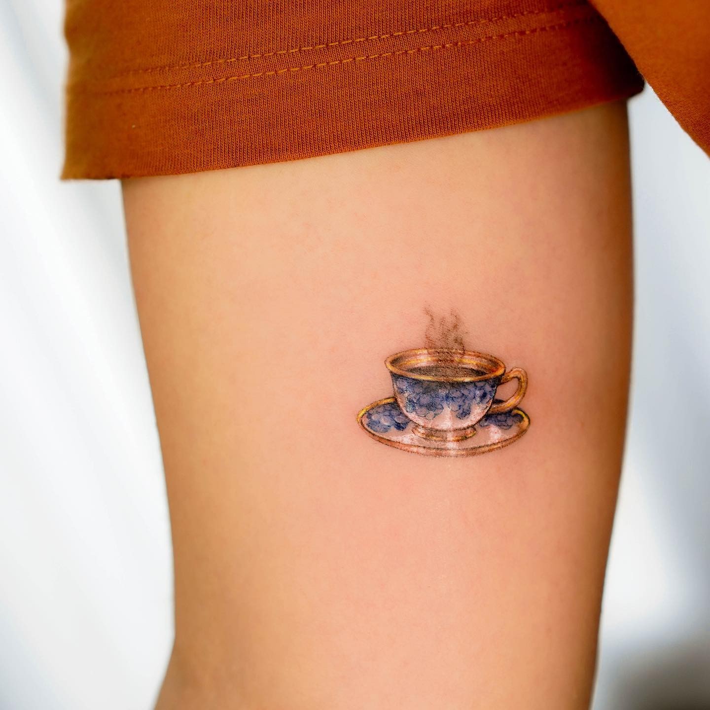 Golden And Blue Teacup Tattoo