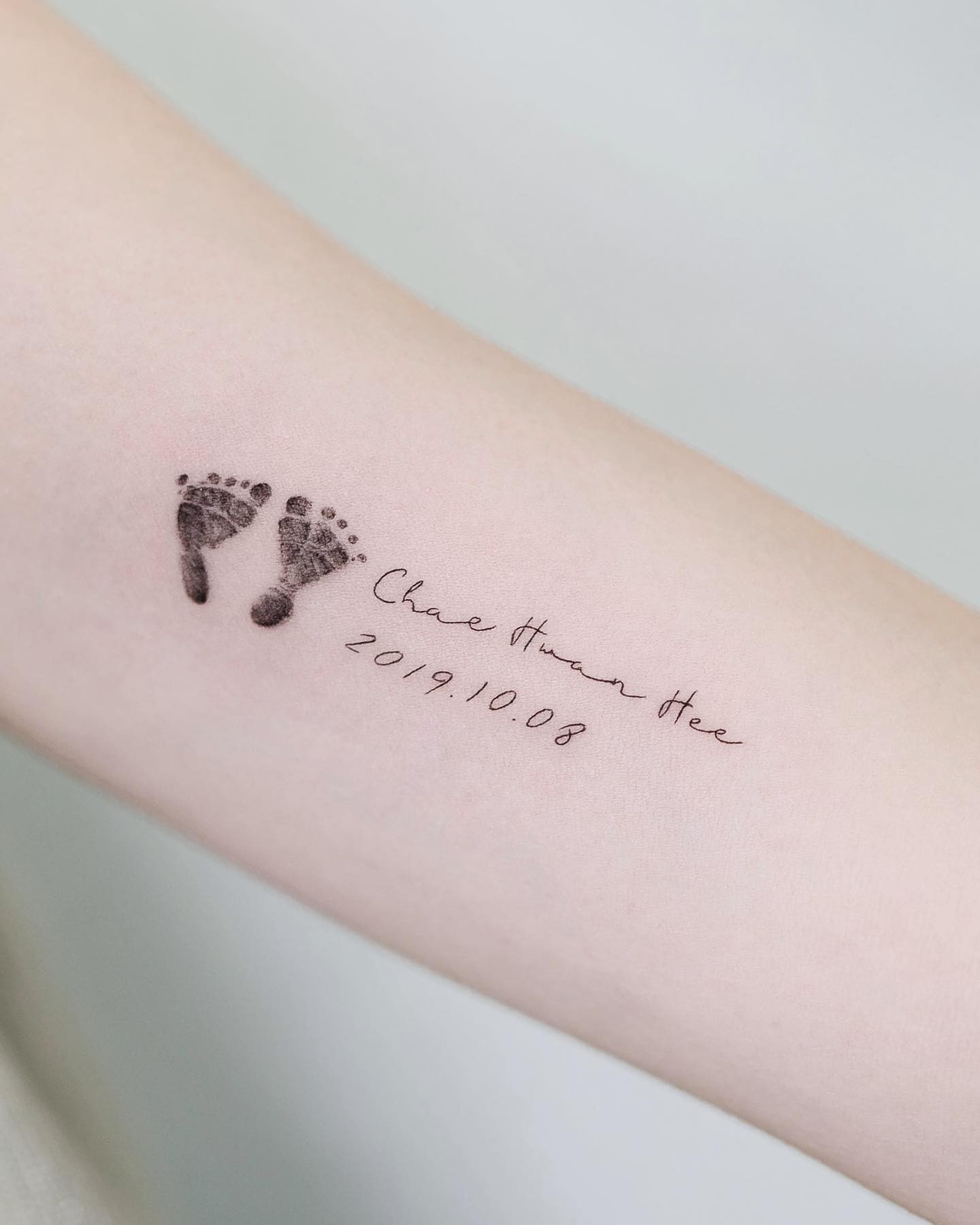 Tiny Footprints With Baby’s Name Tattoo Ideas