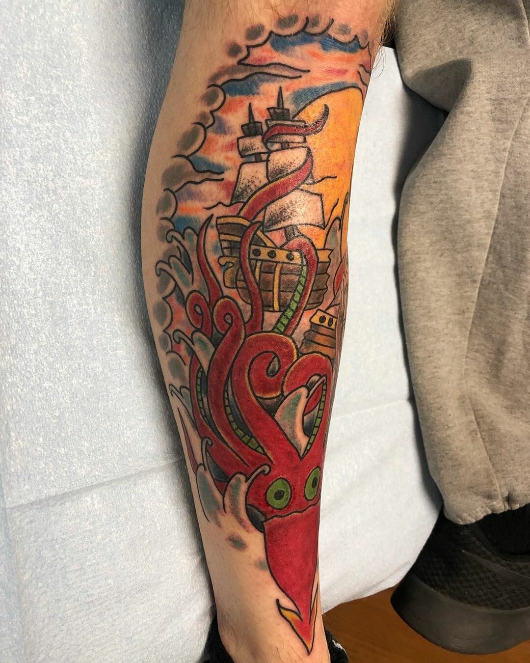 Kraken Tattoo Red Ink Over Leg With Ship Detail