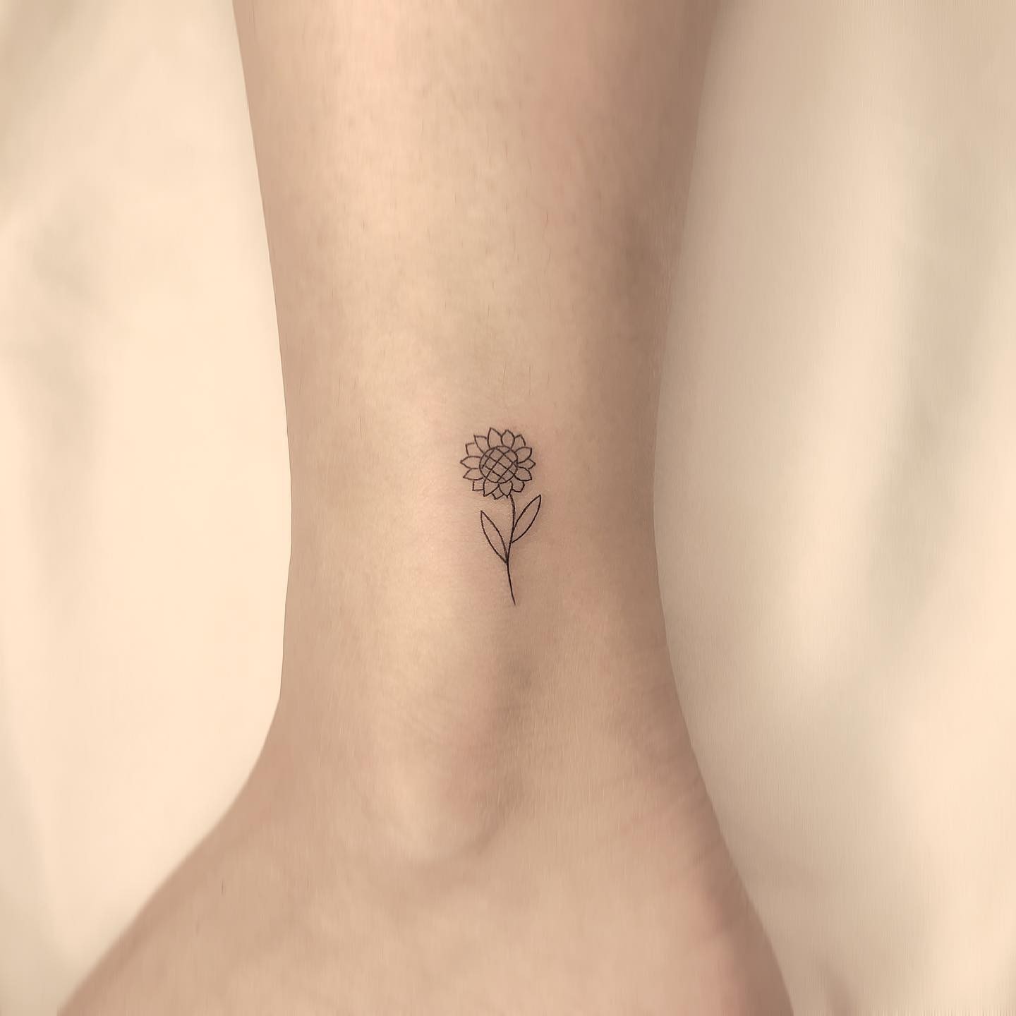 Outlined Small Sunflower Tattoo On Ankle