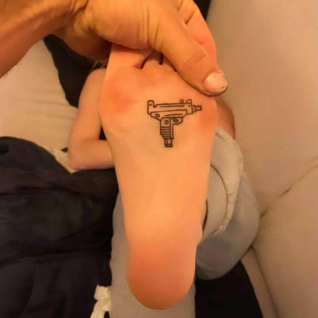 Cute Gun Tattoo On The Bottom Of The Feet