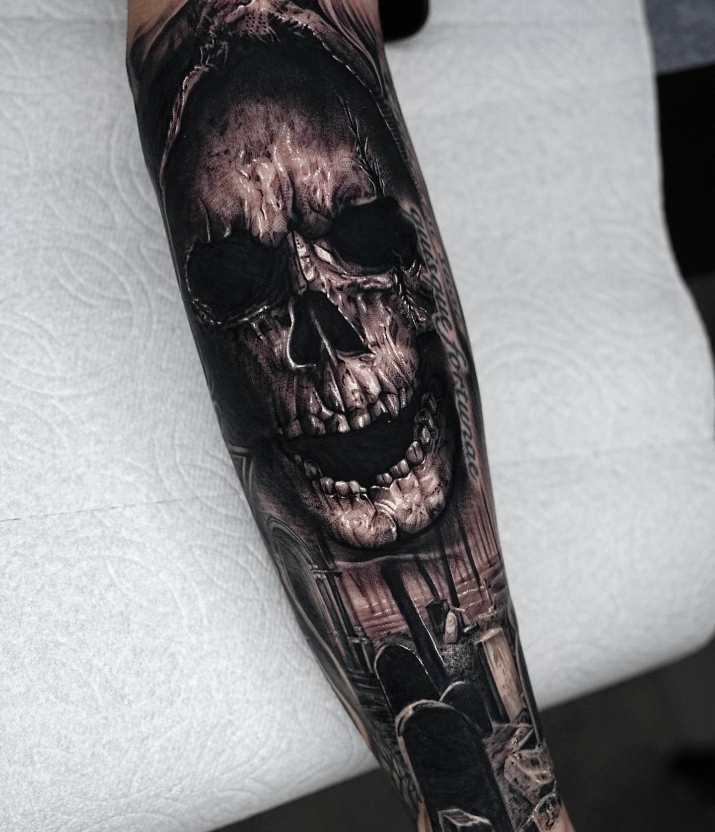 Black Skull With Text Forearm Tattoo