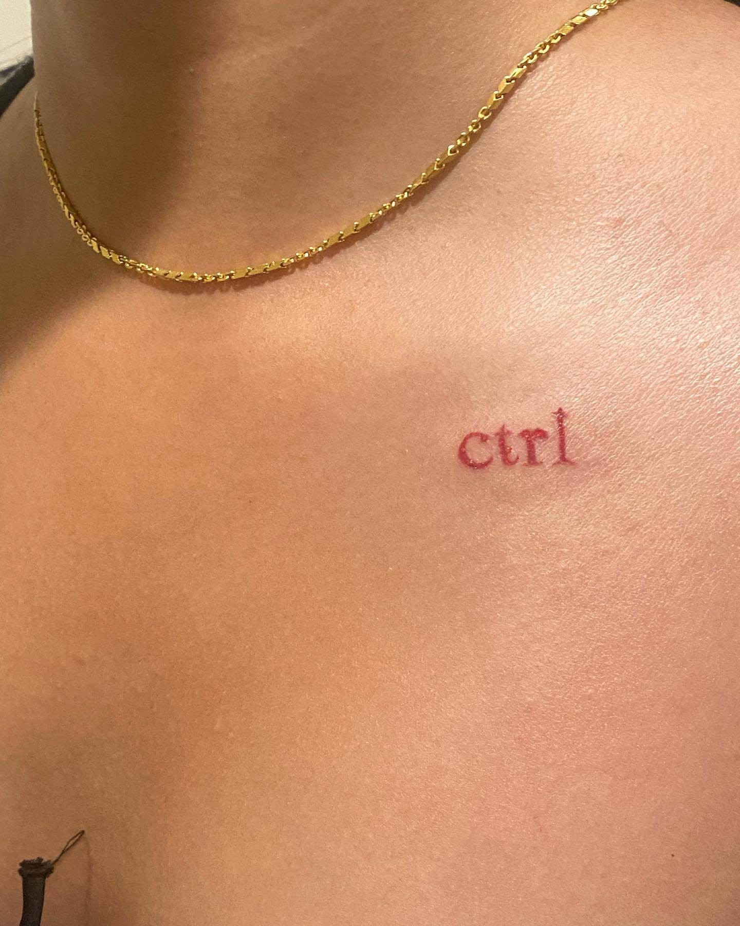 Red Coloured Ctrl Handpoke Tattoo On Collarbone