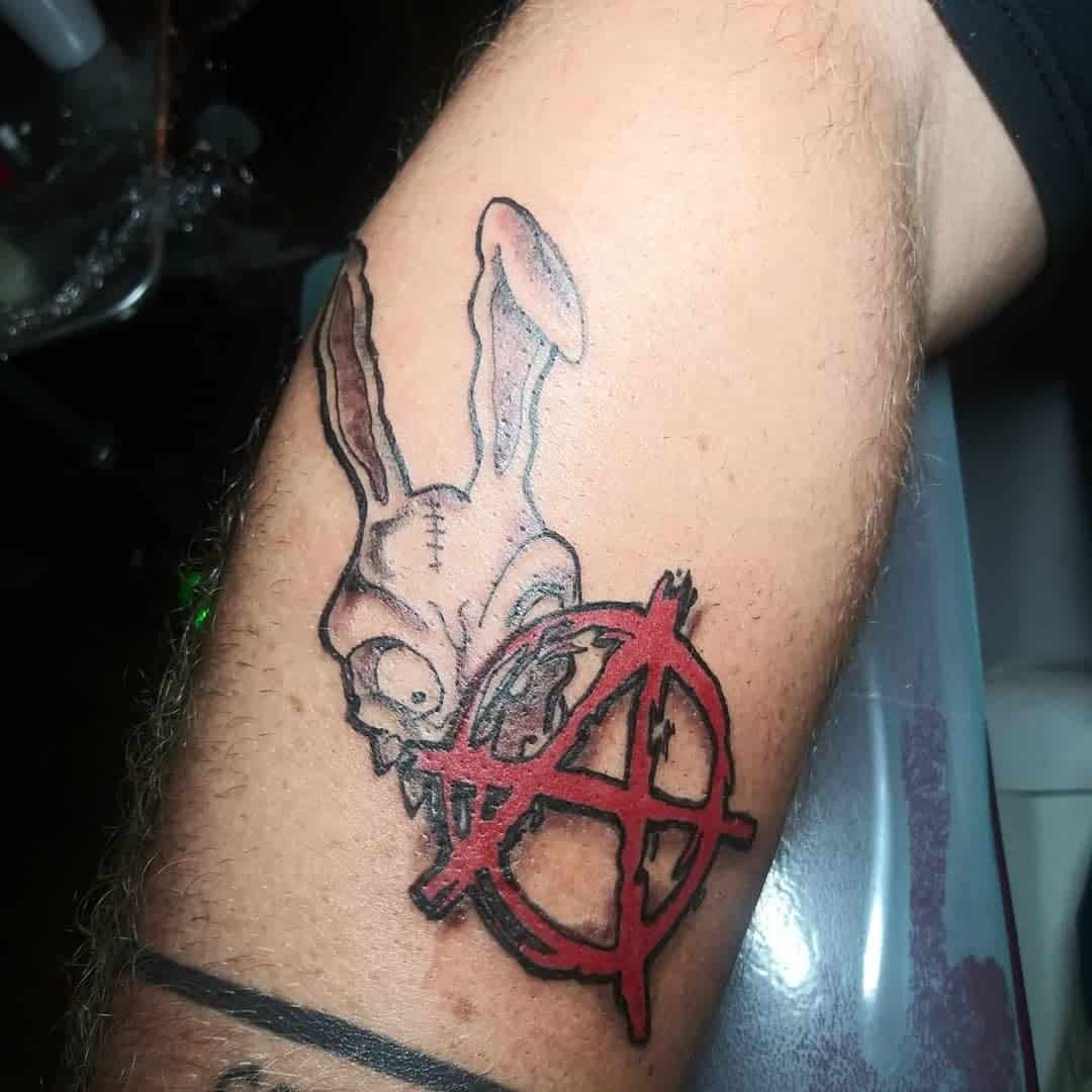 Creepy Bunny And Anarchy Symbol Tattoo In Red Ink Upper Arm Placement Tattoo